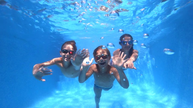 三个快乐的孩子在游泳池里游泳视频素材