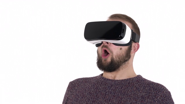 戴着虚拟现实技术小玩意的年轻人。男子惊讶于增强现实在虚拟现实头盔上的白色背景视频素材