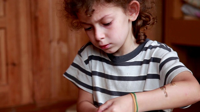 一个孩子在客厅里剪一张纸的特写视频素材