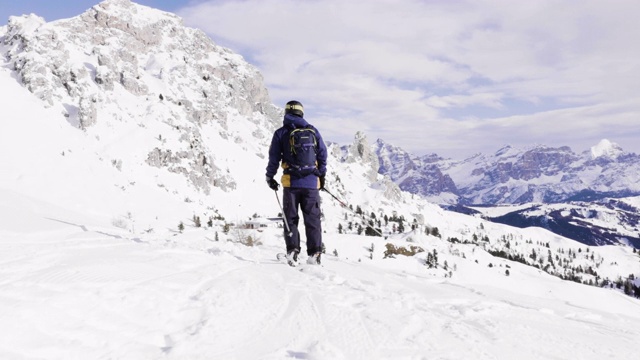 跟随特写:快乐的滑雪者有乐趣滑雪在一个阳光明媚的冬天在雪山的backcountry。极速免费滑雪滑雪者在意大利白云石山滑雪胜地的雪道上骑着新鲜的粉末雪视频素材