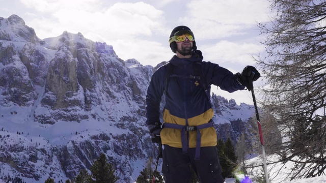 在一个阳光明媚的日子里，意大利多洛米特山脉的滑雪者看着山脉视频素材