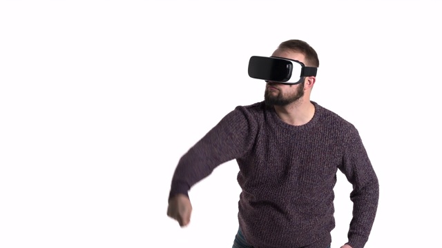一个年轻的大胡子男子在VR眼镜中模仿墙壁绘画的特写演示。娱乐和小玩意概念视频素材