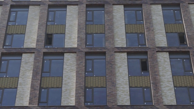 室外拍摄的纽约风格的公寓大楼在白天。窗户和砖立面视频下载