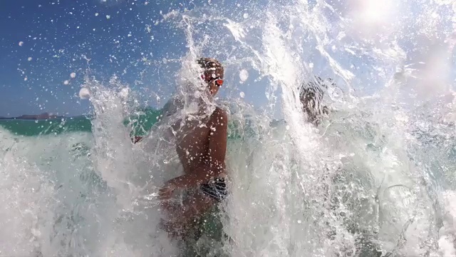 小男孩们在海浪中溅起水花视频下载
