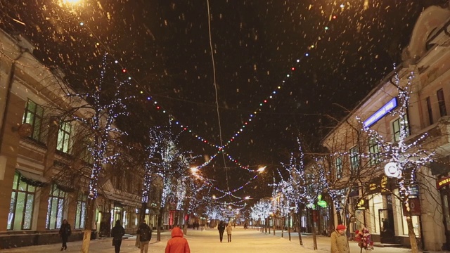 俄罗斯雅罗斯拉夫尔:市中心的夜晚下雪，人们走在覆盖着雪的街道上，冬天的季节视频素材