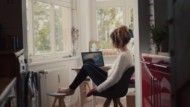 柏林的一个年轻女子，家里有笔记本电脑视频素材