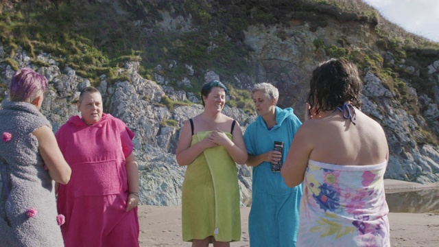 一群在海里游泳后穿衣服的妇女在一起大笑。视频素材