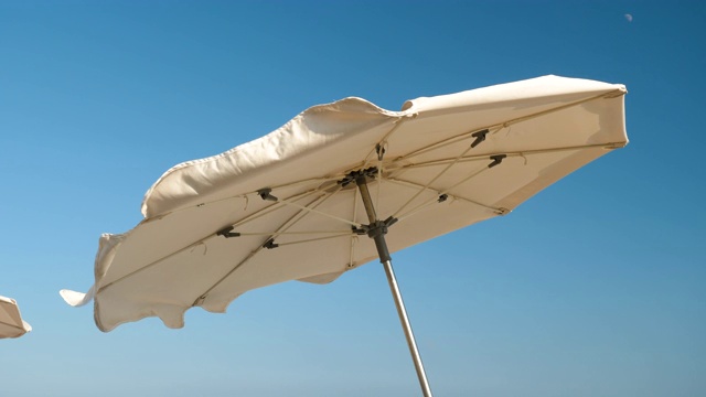 Costa del Maresme海岸。太阳伞在强风上挥舞的特写镜头。西班牙4 k。视频下载