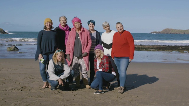 一群妇女站在空旷的海滩上有说有笑视频素材