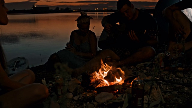 湖边的篝火旁，年轻人在唱歌、弹吉他视频素材