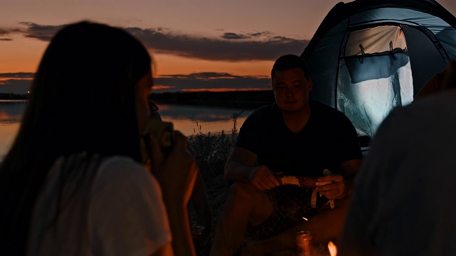 黄昏时分在湖边露营的一群年轻人视频素材