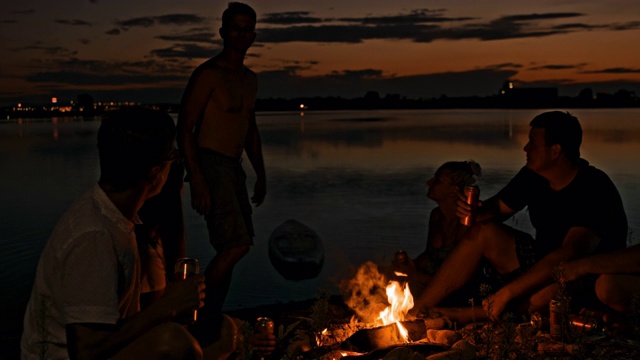 年轻人在湖边篝火旁玩耍视频素材