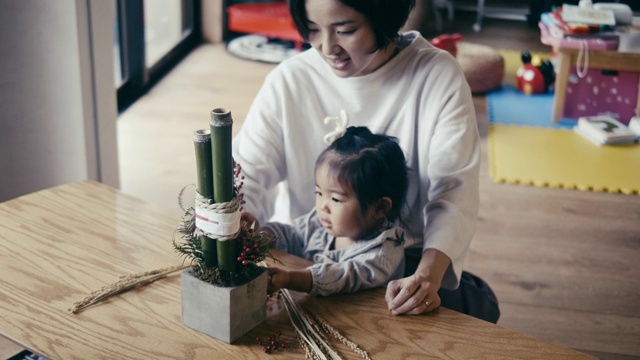 日本母亲和女儿制作除夕装饰(角松)视频素材