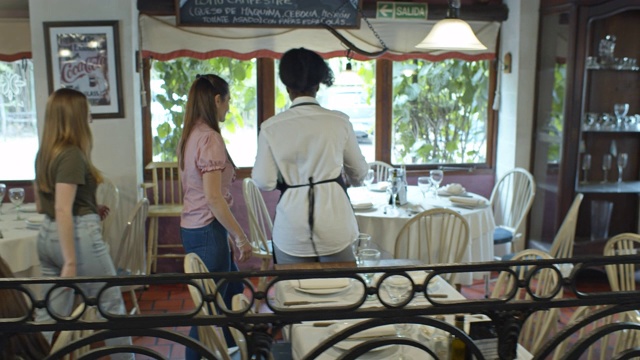 餐厅服务员招呼客人并安排家人就座后的跟踪镜头视频下载