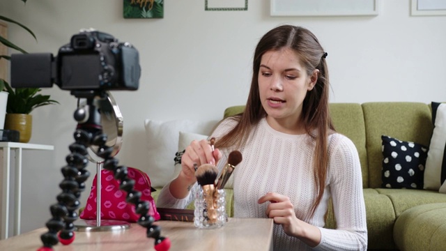 美妆博主正在为你的tube拍摄视频，评论化妆刷视频素材