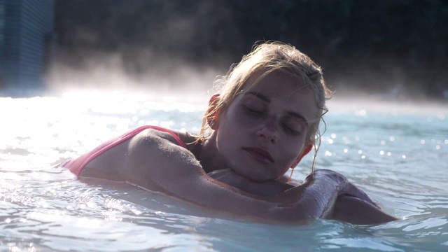 美丽的女子在冰岛的温泉池中放松视频下载