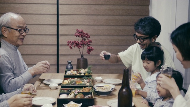 日本几代同堂的家庭在除夕夜吃大石饭前说“kampai”视频素材
