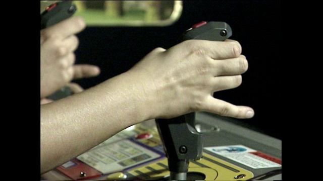 青少年在电子游戏厅使用操纵杆的CU;1998视频下载