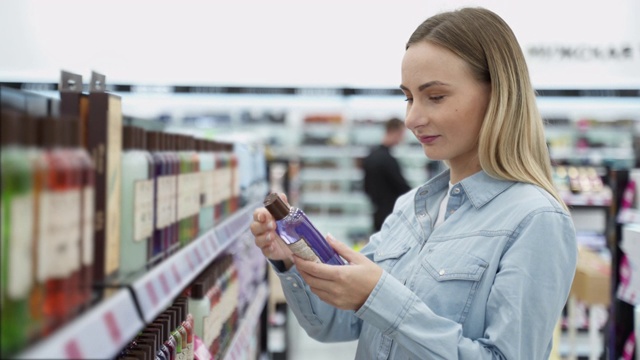 购物-年轻女子拿着一瓶洗发水在超市视频素材