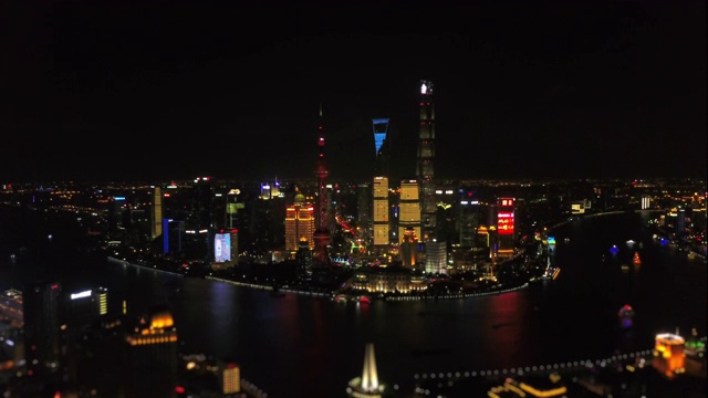 夜景照亮了上海著名的市中心浦东，4k倾斜平移中国航拍全景视频下载