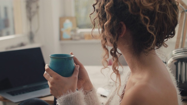 年轻女子在家里喝咖啡视频素材