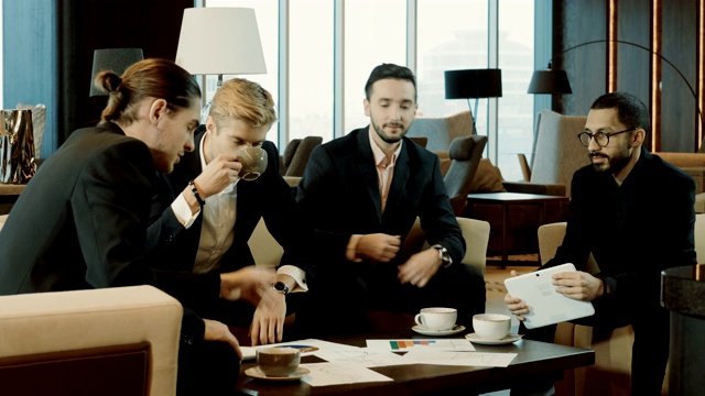 由年轻的四名商人组成的混合种族团队在商务会议上。4 k视频素材