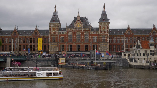 阿姆斯特丹市主要火车站前白天运河交通全景4k荷兰视频下载
