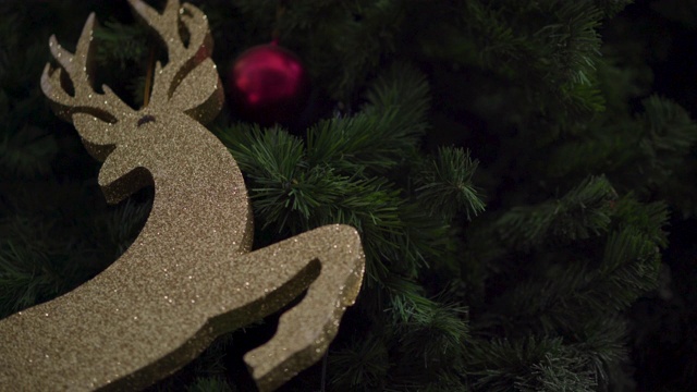 4k驯鹿圣诞树装饰人物挂。金色闪光，装饰球，圣诞快乐，新年快乐，居家室内，礼物玩具礼物，假期周末庆祝，拳击。沉默的夜视频购买