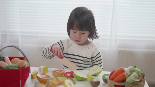 蹒跚学步的女孩在家里假装玩食物准备玩具视频下载