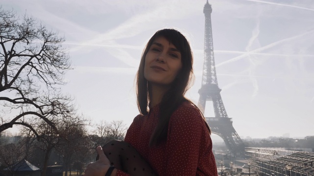 美丽快乐优雅的白人女游客摆姿势，微笑着在史诗般的日出巴黎埃菲尔铁塔慢动作视频素材