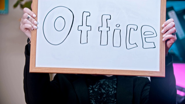 一位女商人挂着一个印有“办公室”字样的名牌视频素材