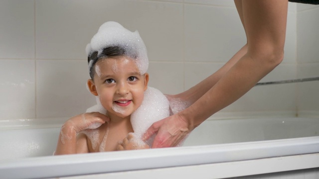 男婴和妈妈在泡泡浴中沐浴视频素材