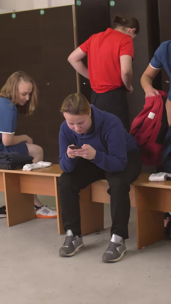 女运动员在更衣室使用智能手机视频素材