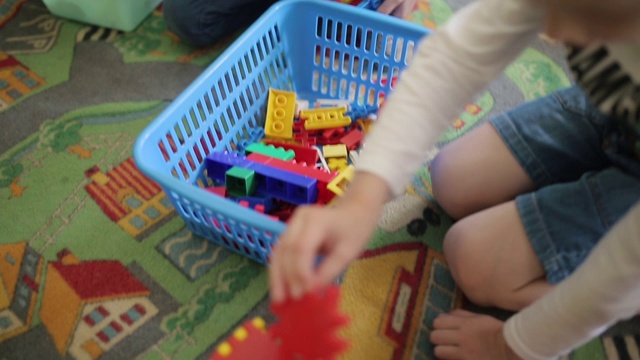 孩子们玩彩色的塑料玩具。汽车游戏。两个男孩收集彩色塑料构造器视频素材