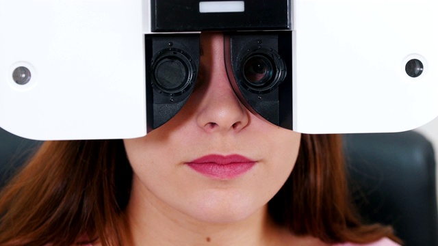 眼科治疗——一位年轻女性用一种特殊的验光设备检查她的视力——一台换镜片的机器视频下载