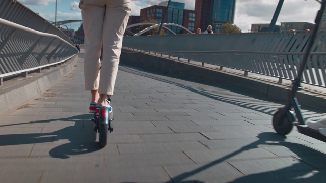 一对夫妇在人行桥上骑电动滑板车视频下载