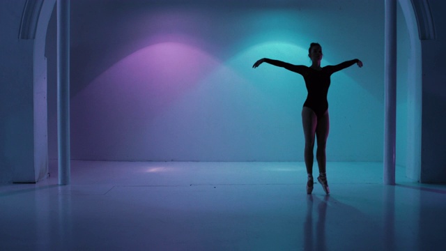 在一个色彩斑斓的演播室里跳舞的芭蕾舞演员视频素材