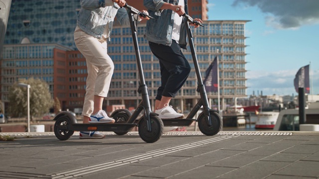一对夫妇在城市里驾驶电动滑板车视频素材