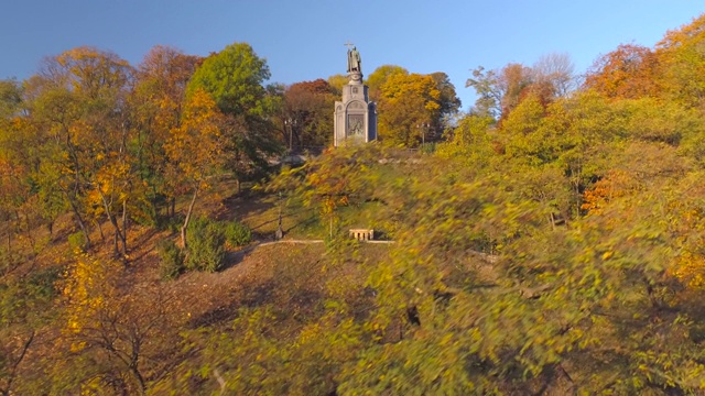 鸟瞰罗斯浸信会圣弗拉基米尔纪念碑，在一个阳光明媚的早晨被秋天的树木包围视频素材