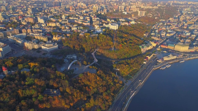 鸟瞰图的城市在一个阳光明媚的秋天早晨在河边的山上视频素材
