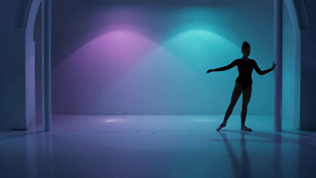 在一个色彩斑斓的演播室里跳舞的芭蕾舞演员视频素材