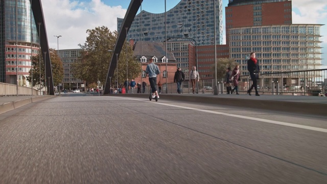 在城市的街道上，一名男子骑着电动踏板车视频素材