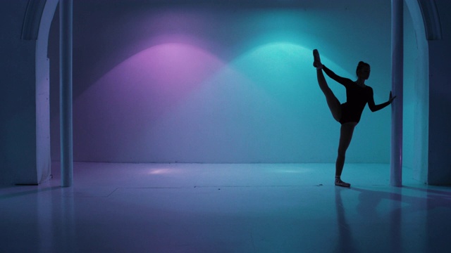 跳舞，年轻的芭蕾舞演员在一个色彩斑斓的工作室视频素材