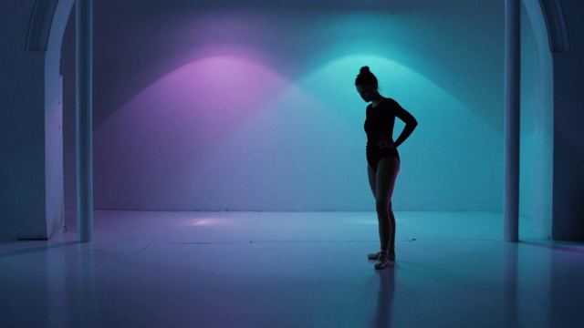 芭蕾舞女演员正坐在地上一个色彩斑斓的画室里视频素材