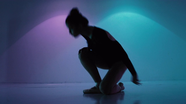 芭蕾舞女演员在一个色彩斑斓的画室里伸展身体视频素材