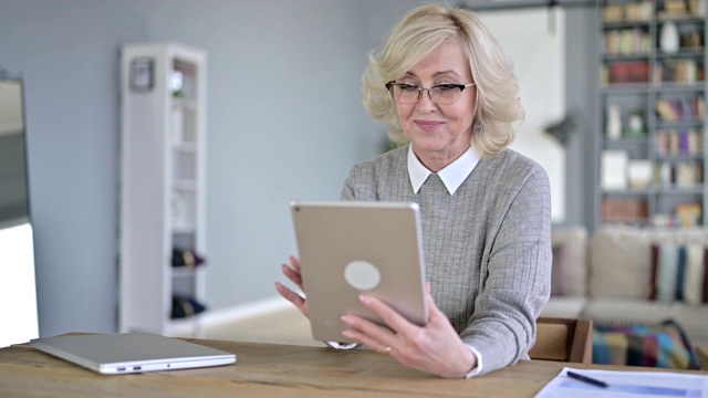 老妇人在现代办公中使用平板电脑视频素材