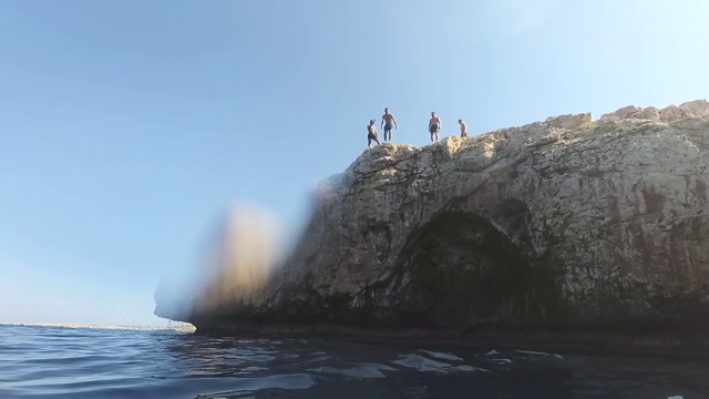 瘦弱的年轻人站在悬崖边上，准备跳入水中，极限运动，恐惧，危险，夏日乐趣视频素材
