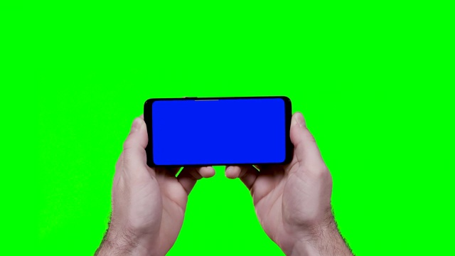 男人的手拿着智能手机水平与蓝色croma键和绿色屏幕的背景视频素材