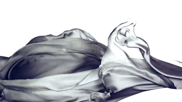 金属银色的丝质织物在超慢的动作中横向流动和摆动，近距离，白色背景视频下载