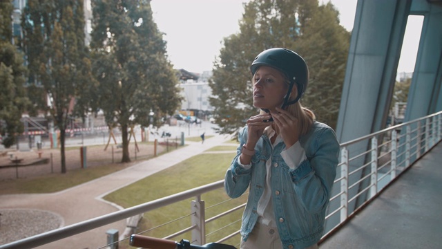 骑电动车时戴头盔的妇女视频素材